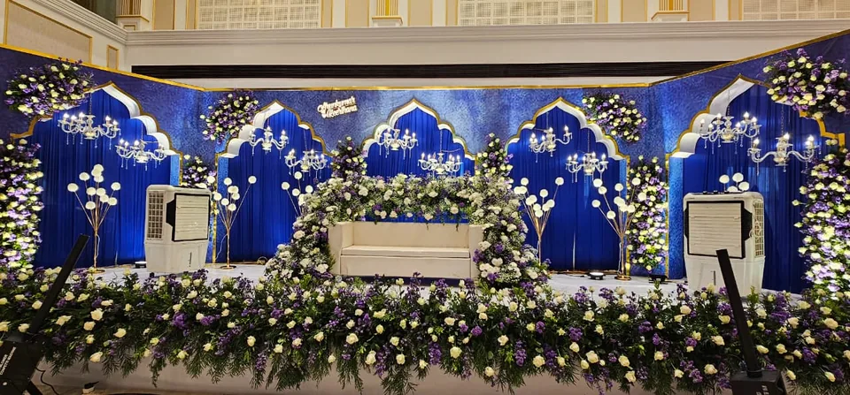 Royal blue stage with white arches and cascading florals