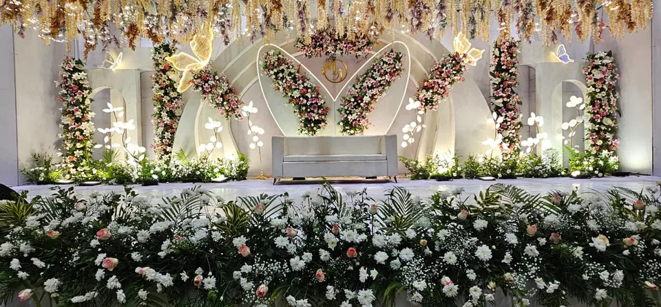 Garden style stage with white blooms, greens and arched panels