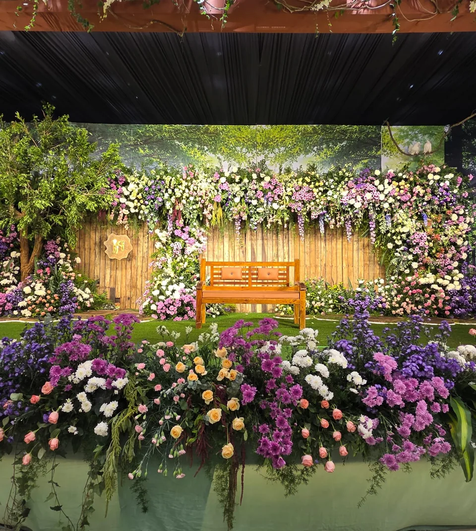 Garden styled floral wall with bench and wildflower planting