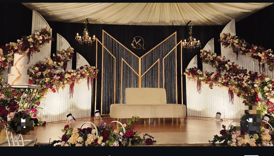 Evening reception stage with monogram, drape canopy and rich florals