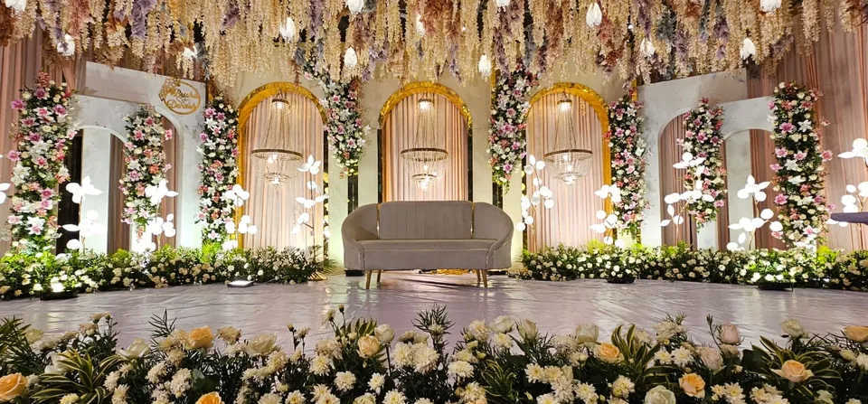 Golden stage with arched doors, hanging florals and classic sofa