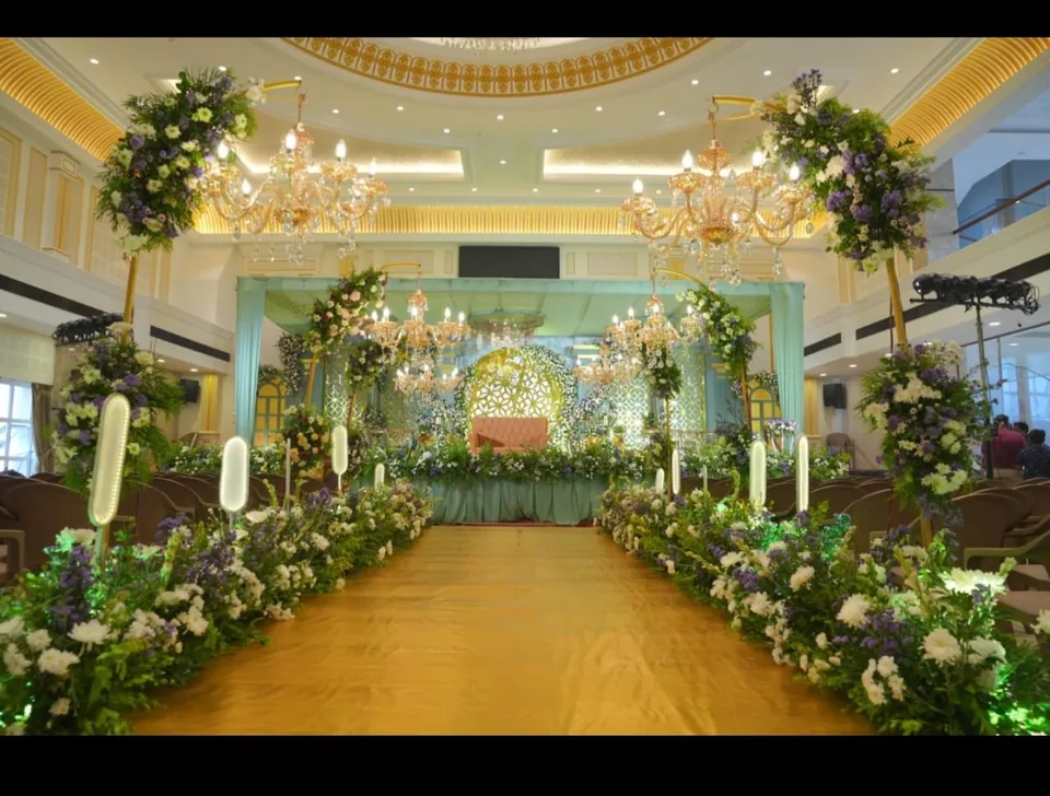 Grand ballroom aisle with floral columns and mint accents