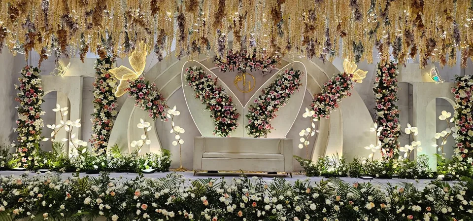 Heart shaped floral arch wedding stage with pastel flowers and warm lighting