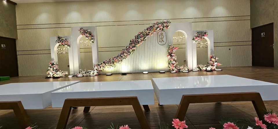Sculpted S-curve platform with pink florals and spot lighting