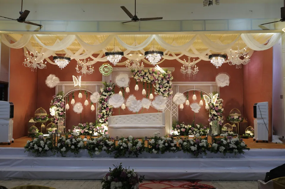 Terracotta suite stage with oversized white blooms and chandeliers
