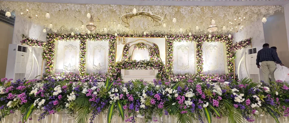 Luxury white floral wedding stage with hanging blossoms and crystal chandelier